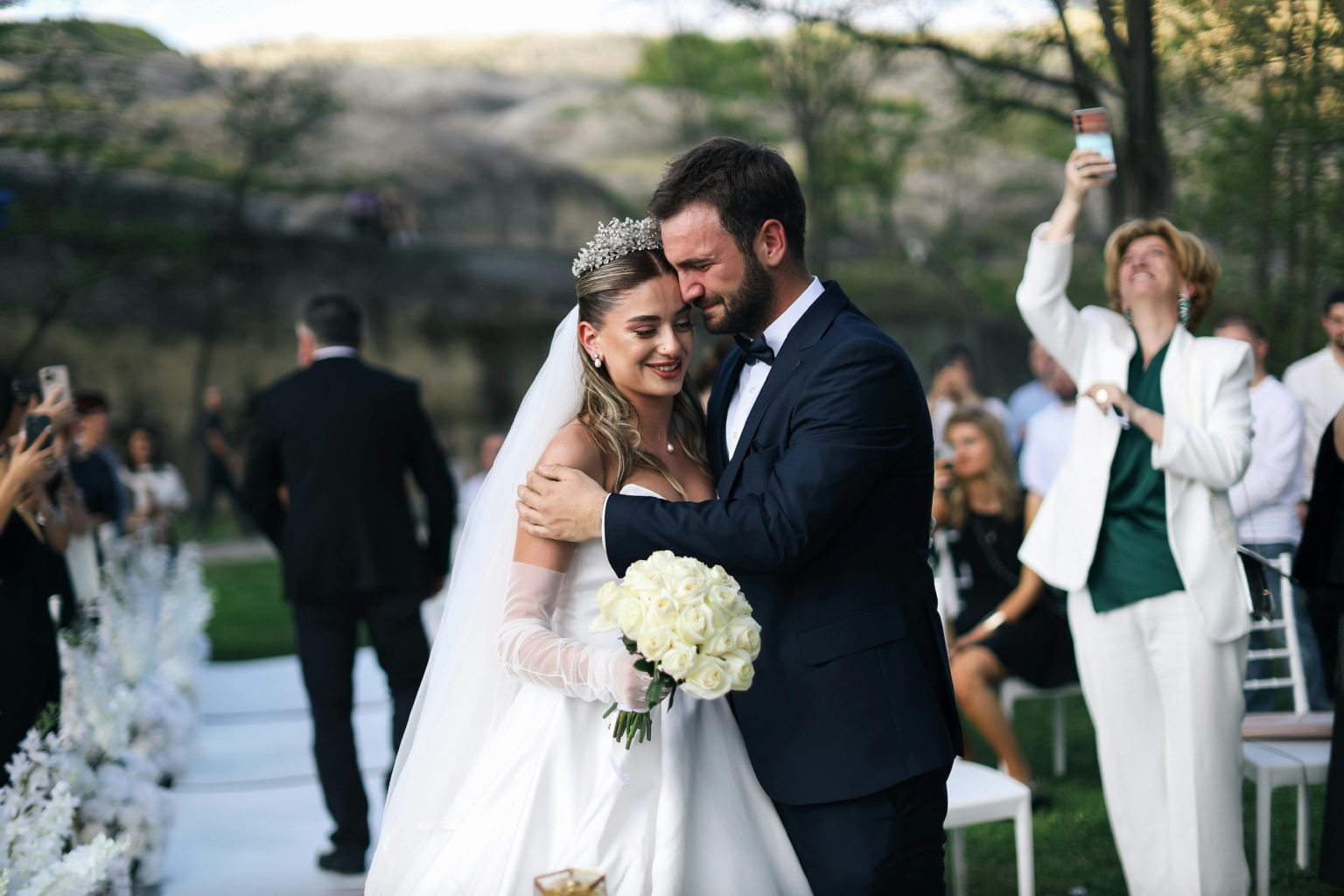 Beautiful outdoor wedding ceremony featuring a happy bride and groom embracing.