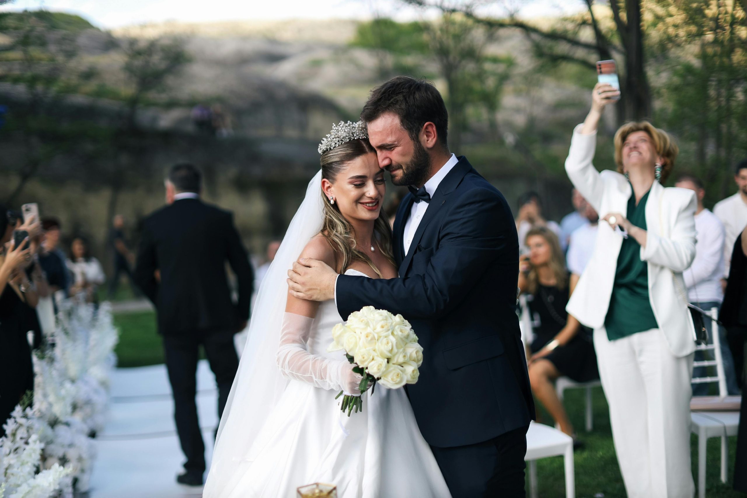 Beautiful outdoor wedding ceremony featuring a happy bride and groom embracing.